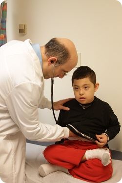 doctor checking heart of young boy 