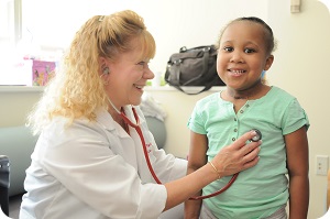 doctor checking heart of young patient 