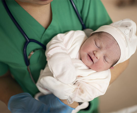 nurse holding a newborn baby