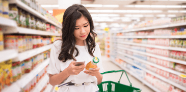 woman grocery shopping and checking the label