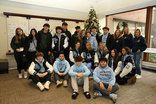 Members of the Freehold Regional High School Football and Cheer Club await the riders in the Monmouth Medical Center entry foyer.