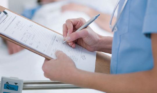 Doctor writing on a patient's chart
