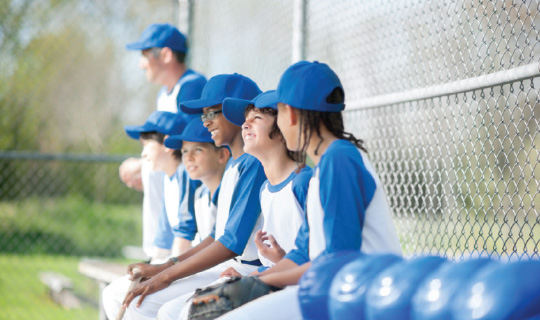 young baseball players sitting together on the bench