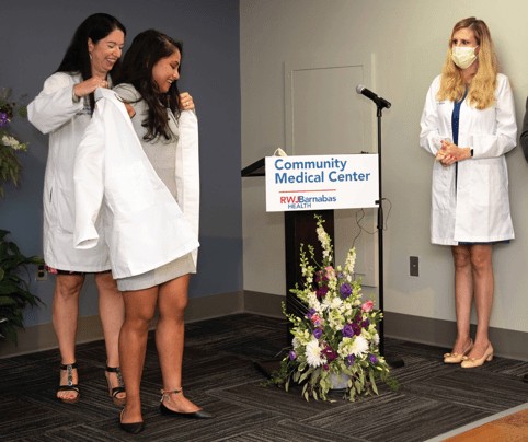 Nileena Johnkutty, DO,
receives the long coat of
a physician from Nicole
Maguire, DO, Program
Director, Emergency Medicine
Residency Program