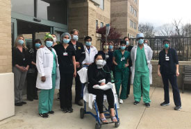 Physicians and staff join in the “clap out” of a discharged COVID-19 patient
