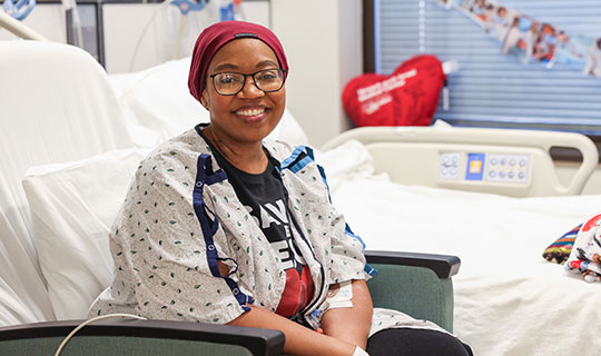 Naiya sitting in a chair in her hospital room at Newark Beth Israel Medical Center