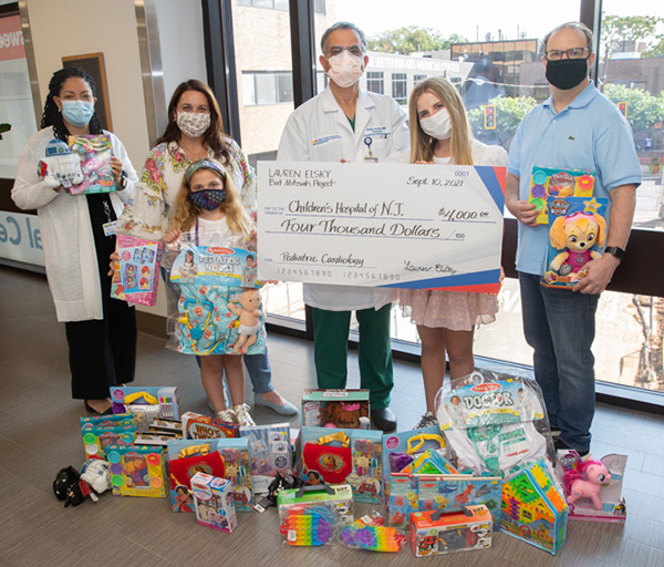 Rajiv Verma, MD with Lauren Elsky during her and her family's visit to make a donation to the Child Life Department
