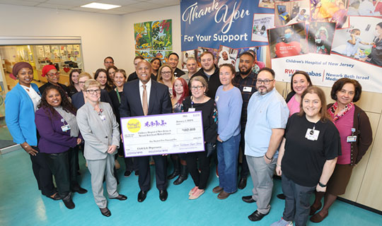 Darrell K. Terry, Sr., MHA, MPH, FACHE, FHELA, President and Chief Executive Officer holding the check surrounded by people from both CHoNJ and the Spirit of Halloween