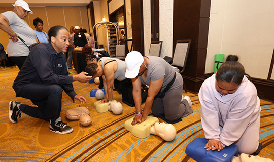 Women’s Health Day attendees practice CPR cardiopulmonary resuscitation on medical manikins