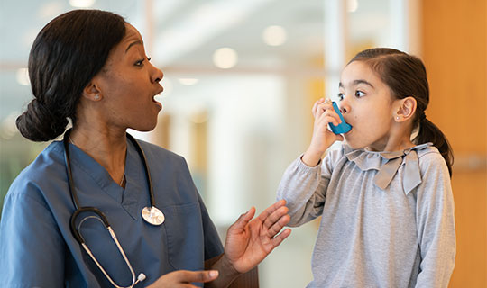 Respiratory therapist and her patient using an inhaler