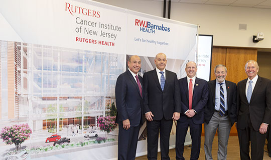 Members from RWJBarnabas Health, Rutgers Health, and the Mayor of New Brunswick, James T. Cahill in front of the rendering of the new CINJ Cancer Pavilion