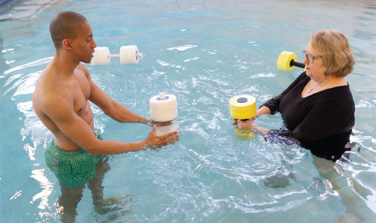 A Patient and Instructor exercising in the pool