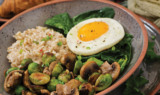 savory oatmeal with a poached egg and greens