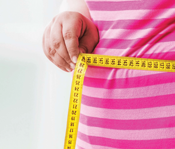 Image of Person Holding Measuring Tape Around Stomach