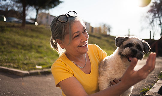 woman holding her dog and smiling