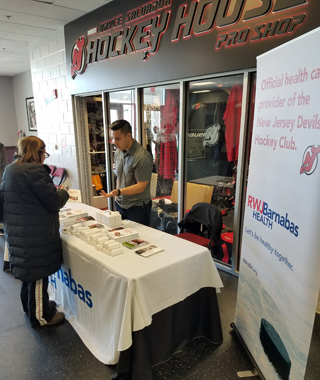 Mustafa Naematullah, Program Coordinator, Matthew J Morahan Center for Athletes, speaking with Youth Hockey parents about the benefits of the Morahan Center at the NJ Devils Learn to Play session in the RWJBH Hockey House