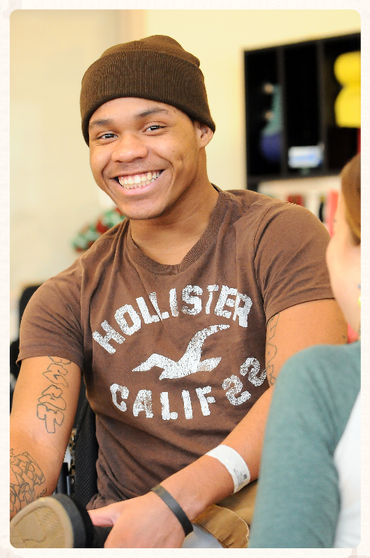 man in brown shirt and beanie smiling 