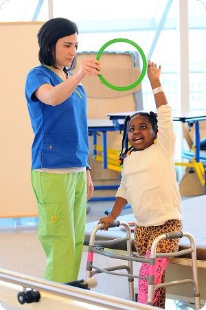 little girl exercising with nurse