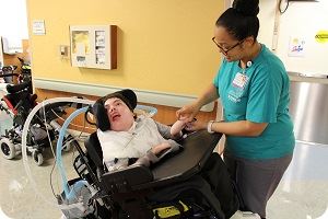 nurse helping special child in wheelchair 