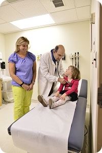 little girl being checked by doctor