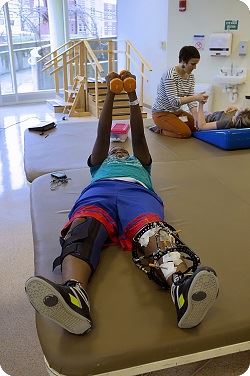 child on mat holding weights above head 