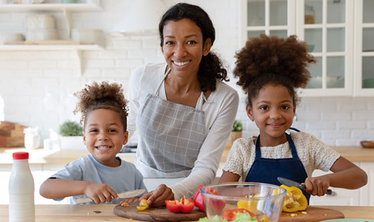 two children cutting peppers in a cooking class