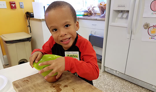 Mason chopping apples on a cutting board