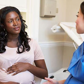 pregnant woman speaking with a nurse