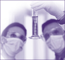 Medical laboratory technicians reviewing liquid sample in vial