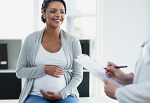Smiling pregnant woman with doctor