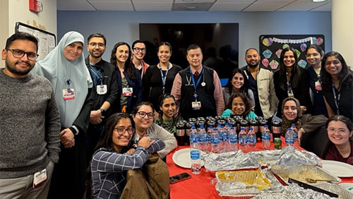 group of residents standing around a table with Dr. Sicat