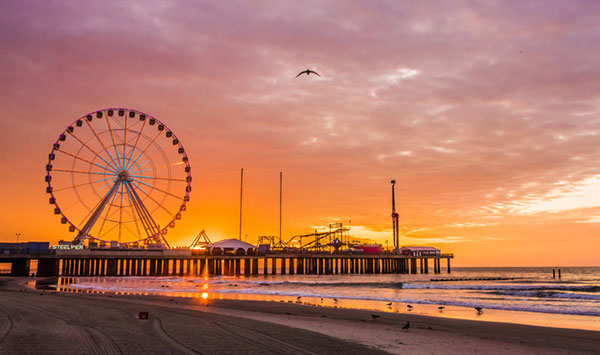 Sunset on the beach in Atlantic City New Jersey with a ferris wheel in the background